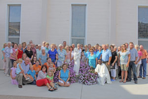 Barb Arland-Fye Catholics pose in front of the newly formed Our Lady of the Holy Rosary Catholic Church in Lost Nation Aug. 15. Two longtime parishes, Sacred Heart in Lost Nation and St. James in Toronto, merged to establish Our Lady of the Holy Rosary. The new parish and parishes in Grand Mound and Oxford Junction are served by Father Francis Odoom of Ghana, Africa. 