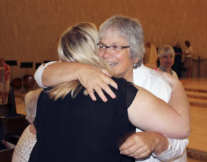 Barb Arland-Fye Sister Kathy Flynn, O.P., shares a hug during the Aug. 2 Mass at which she made her first profession of vows with the Sinsinawa Dominican Congregation in Sinsinawa, Wisconsin.