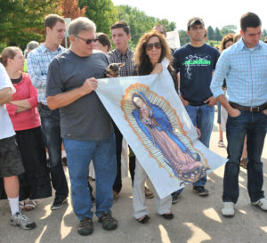 Lindsay Steele Tom and Joan Crider of Jesus Christ, Prince of Peace Parish in Clinton hold an Our Lady of Guadalupe tapestry during a National Day of Protest event in front of Planned Parenthood in Bettendorf Aug. 22. Participants were protesting Planned Parenthood’s sale of body parts of unborn, aborted children and also seeking an end to abortion. 