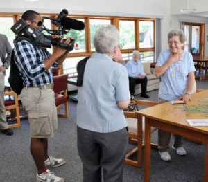 Lindsay Steele Mary Costello surprises Jan Pullella, an associate for the Congregation of the Humility of Mary, with $300 from WQAD-TV and Ascentra Credit Union’s “Pay it Forward” campaign Aug. 11. WQAD-TV photographer Jaawan Arrington records the moment.