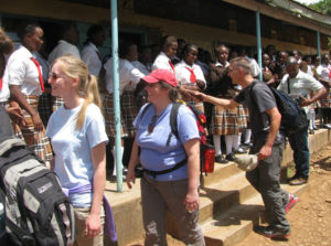 Contributed St. Mary-Pella parishioners Mary Masek, Donna DeJoode, Jim Masek and Father Charles Gituma shake hands with students at Nkabune Secondary School in Kenya during a mission trip earlier this summer. Prior to the trip, St. Mary parishes in Pella, Oskaloosa and Iowa City raised money to help restore the school dormitory after a fire in 2014. 