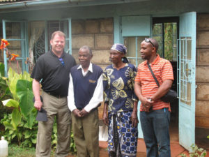 Contributed Father Jeffry Belger, parochial vicar at St. Mary Parish and campus minister at the Newman Catholic Student Center, both in Iowa City, visits Father Charles Gituma’s parents, center, in Kenya during a mission trip earlier this summer.  Fr. Gituma, right, was born in Kenya and assists at parishes in Oskaloosa and Pella.