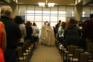Anne Marie Amacher Bishop Martin Amos sprinkles holy water on students, faculty and staff at St. Ambrose University in Davenport. The annual convocation and blessing of the school year was held Aug. 25 in the Rogalski Center. 