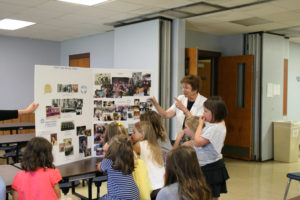 Anne Marie Amacher Sister Judy Herold, SSND, shows pictures of herself with her family and congregation over the years to girls at the Our Lady of Lourdes Little Flowers Catholic Girls’ Club Sept. 13. 