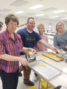 Judy Schneider Father Jake Greiner, pastor of parishes in Knoxville and Dallas-Melcher, makes homemade noodles with Sacred Heart-Dallas-Melcher parishioners Pat Schneider, Jean Gass and Bonnie Colwell earlier this month.