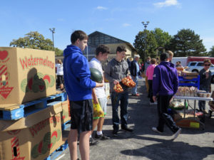  Anne Marie Amacher Assumption High School students, from left: Drew Boldt, Joseph Rapp and Nathan Motley get ready to distribute items during a mobile food pantry at Our Lady of Lourdes Parish in Bettendorf Oct. 10. 
