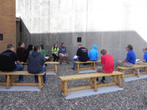 Contributed Robert Rippenkroeger, right, listens to speech class students at Holy Trinity Junior/Senior High School’s new outdoor classroom in Fort Madison Oct. 1. The classroom honors former science teacher Scott Strabala, who died in 2013 at the age of 63.