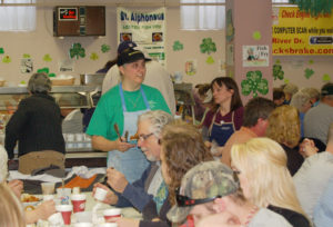 Contributed Volunteers serve and guests dine at a St. Alphonsus Parish-Davenport fish fry in this file photo.