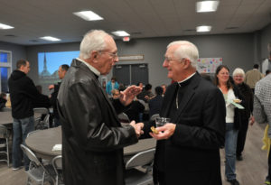 Lindsay Steele Longtime St. Peter-Cosgrove member Jack Ruth celebrates the parish’s new hall Feb. 20 with Bishop Martin Amos. Parishioners of the growing rural church donated money, time and talent to make the new parish hall a reality.