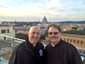 Contributed Father Marty Goetz, left, and Father David Brownfield were both named Missionaries of Mercy and commissioned Feb. 10 by Pope Francis. Here they are pictured with St. Peter’s Basilica at the Vatican in the background.