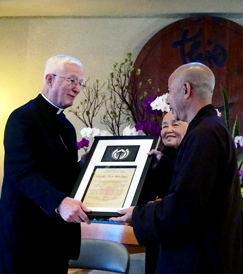 Ron Forster Chan Khong and Brother Phap Dang accept the Pacem in Terris Peace and Freedom Award from Bishop Martin Amos on behalf of recipient Thich Nhat Hahn in southern California last October. A local celebration will be held April 2 in Davenport.