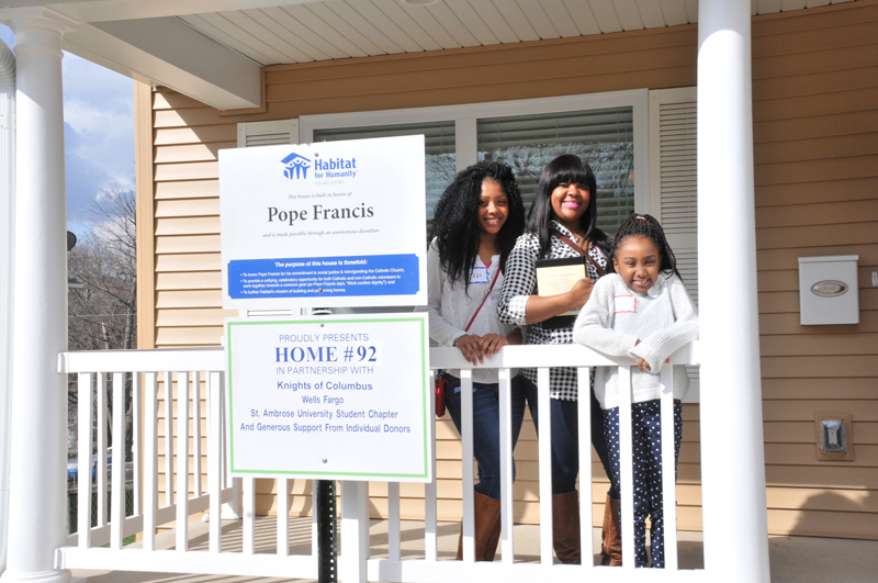 Lindsay Steele Avita Hicks, center, and her daughters Jada and Adrianne, stand on the front porch of their new home after a Habitat for Humanity dedication ceremony March 19. 