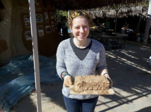 Contributed St. Ambrose University student Sophie Foreman holds a homemade brick at Kibbutz Lotan, an eco-Jewish community in Israel. A study abroad program provided the students to learn about social justice issues in the Middle East.
