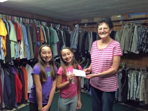 Contributed Keira, left, and Korrine Davison presented Mary Gillooly with a check for $67 for the Sacred heart Clothing Center in Davenport. The twins raised money by selling lemonade. 