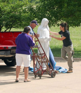 Contributed Harry Krahn, center, and Devin Housenga, right, of Ashford University’s maintenance department in Clinton, delivered a statue of St. Clare to The Canticle, also in Clinton. Waunita Sullivan, also of the university, helped with the delivery.