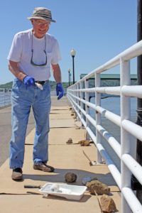 Barb Arland-Fye Bishop Martin Amos paints a railing along the Mississippi River at Fort Madison’s Riverview Park.