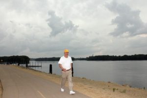 Barb Arland-Fye Father Ken Kuntz, pastor of Prince of Peace Parish in Clinton, walks along the Clinton riverfront July 13. A new wellness document for priests will be promulgated this year.