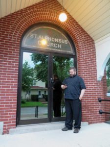 Anne Marie Amacher Father Paul Appel looks at his parish information provided on the popular Pokemon GO app on his smartphone. The game gets people out in the community to various spots, including many churches, and has a host of activities to do on the phone.