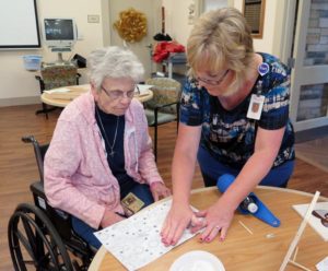 Anne Marie Amacher Pat Frederking prepares a frame for an art project with the help of Lisa Hass, life enrichment supervisors at the Kahl Home in Davenport.