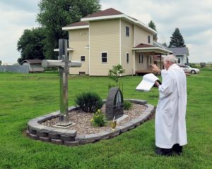 Anne Marie Amacher Father Paul Connolly blesses a memorial at the site of the former St. Anne Parish in Welton on July 24.