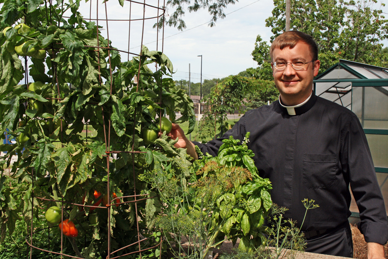 Barb Arland-Fye Father Thom Hennen shows off some of his tomatoes that he is growing this summer.