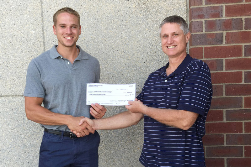 Contributed Grand Knight Joe Keitel presents a check to seminarian Andrew Rauenbuehler to help support his religious formation studies. 