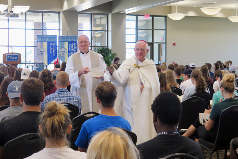 Anne Marie Amacher Bishop Martin Amos sprinkles holy water on new students during the convocation and blessing of the new academic year at St. Ambrose University in Davenport. Assisting the bishop Aug. 23 was Father Chuck Adam, the university’s chaplain.