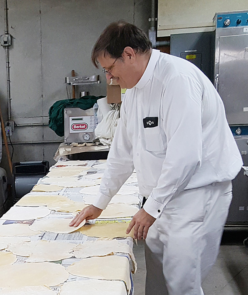 Lindsay Steele Father David Brownfield checks noodle dough for dryness Aug. 22.
