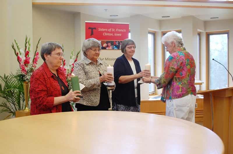 Contributed Prayer leader Sister Ida Green, OSF, right, presents candles to the new leaders of the Clinton Franciscans at an installation ceremony Sept. 3. They are, from left, Sisters Janice Cebula, Marilyn Huegerich and Kathleen Holland. 