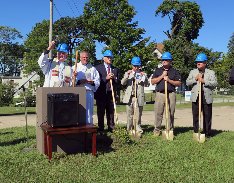 Anne Marie Amacher Bishop Martin Amos, left, sprinkles holy water at the groundbreaking ceremony Sept. 11 for the new diocesan parish hall. The hall will be built onto Sacred Heart Cathedral in Davenport.