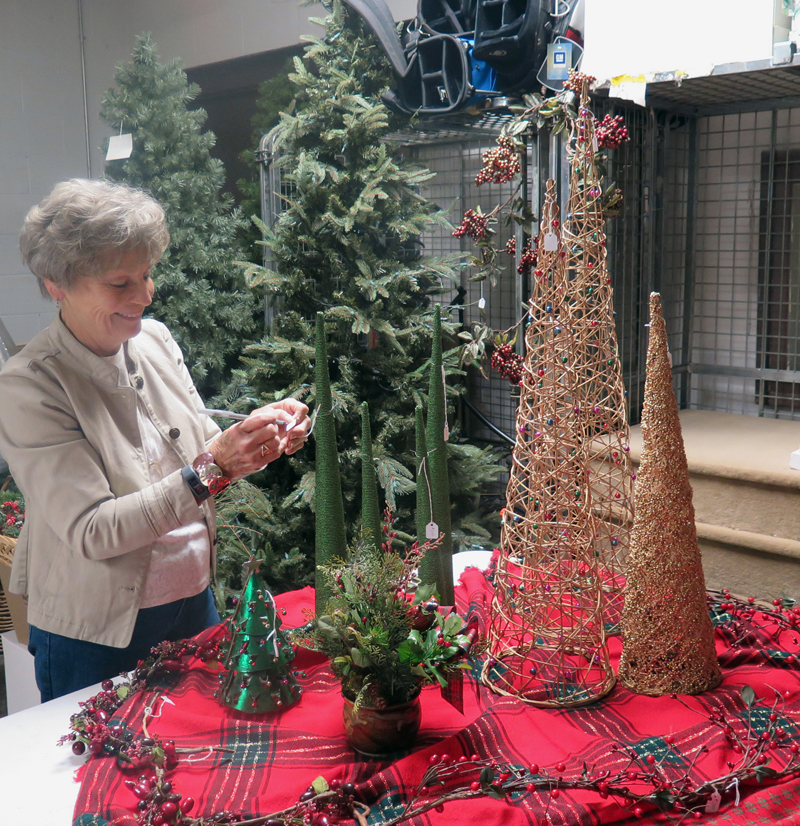 Anne Marie Amacher Carol Harrison of the Catholic Service Board prices a decorative Christmas tree in preparation for the Christmas open house on Nov. 5 at Cinderella’s Cellar.