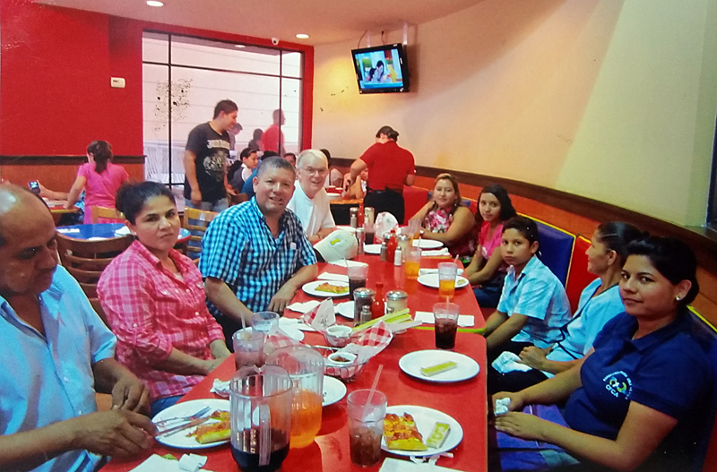 Contributed Father Dennis Martin and the Duran family of West Liberty meet with their sponsor children, family and Unbound staff in this 2013 photo in San Salvador, El Salvador. 