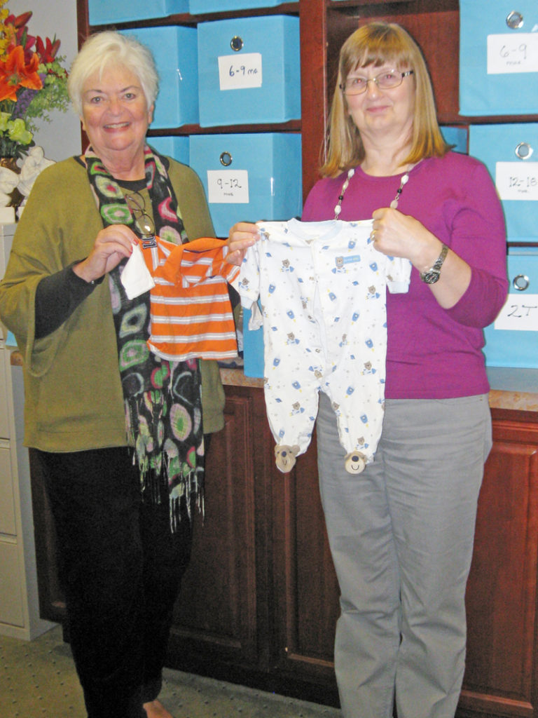 Contributed Connie Williams, left, and Angelika Peiffer show off some baby clothes donated to the Women’s Choice Center in Bettendorf.